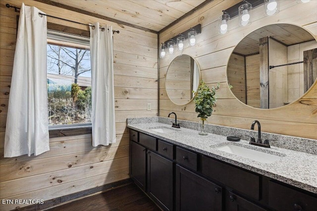 bathroom with wooden ceiling, wood walls, and vanity