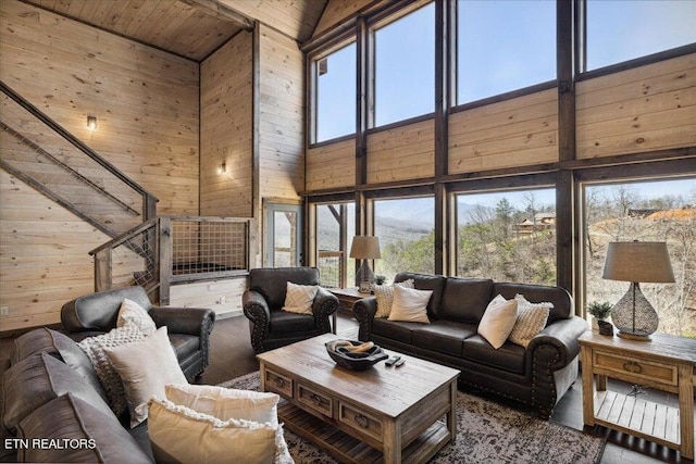 living room featuring wood walls, high vaulted ceiling, and wooden ceiling