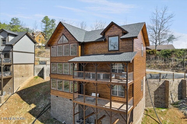 exterior space with a balcony and a shingled roof