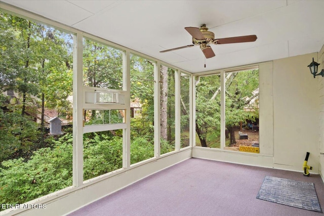 unfurnished sunroom featuring ceiling fan