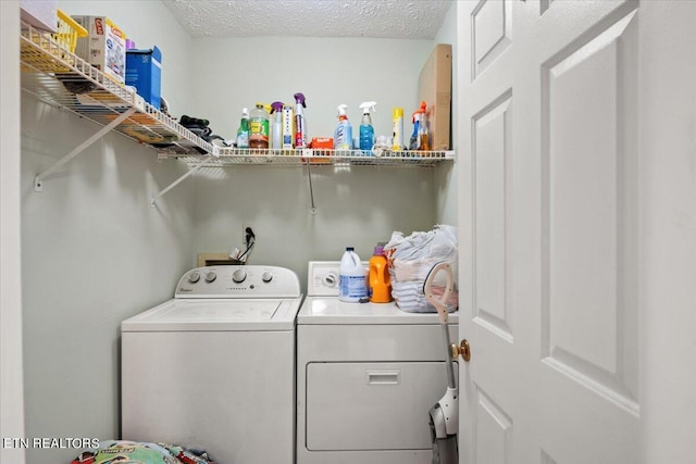 clothes washing area featuring washer and clothes dryer and a textured ceiling