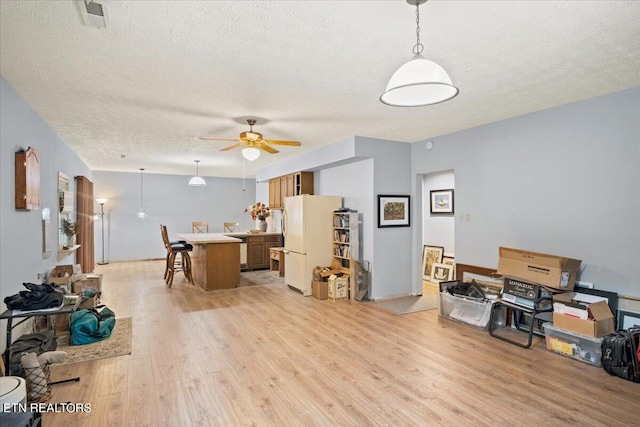 interior space featuring a textured ceiling, light hardwood / wood-style floors, and ceiling fan