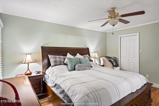 bedroom with wood-type flooring, a closet, ceiling fan, and crown molding