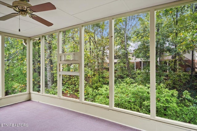 unfurnished sunroom featuring ceiling fan