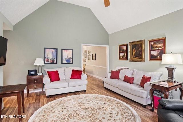 living room with wood-type flooring, high vaulted ceiling, and ceiling fan