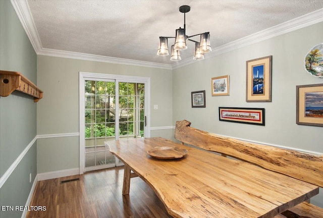 dining room with hardwood / wood-style floors, ornamental molding, a textured ceiling, and an inviting chandelier