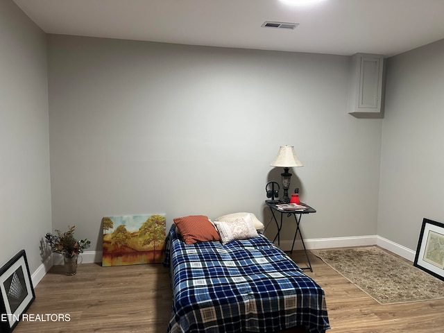 bedroom featuring hardwood / wood-style flooring and heating unit