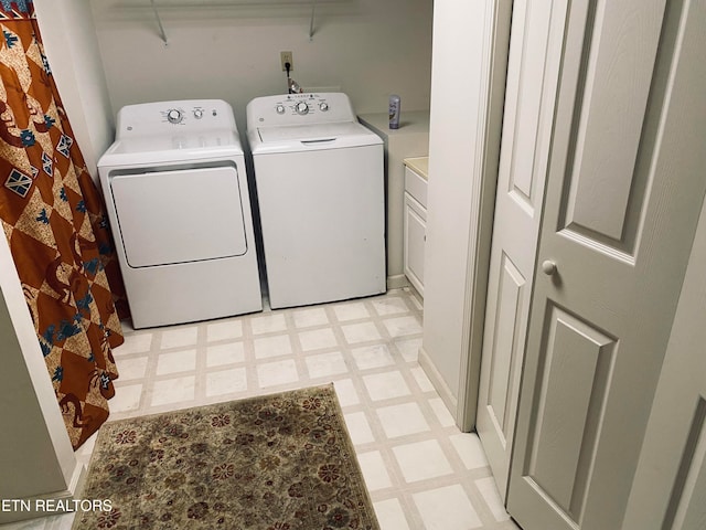 washroom featuring washer and dryer and cabinets