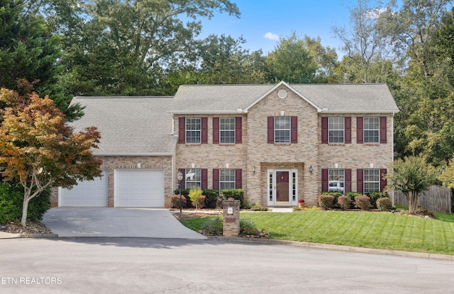 colonial house with a front yard and a garage