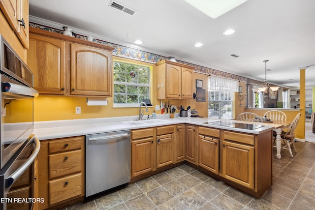 kitchen with hanging light fixtures, stainless steel dishwasher, sink, and plenty of natural light