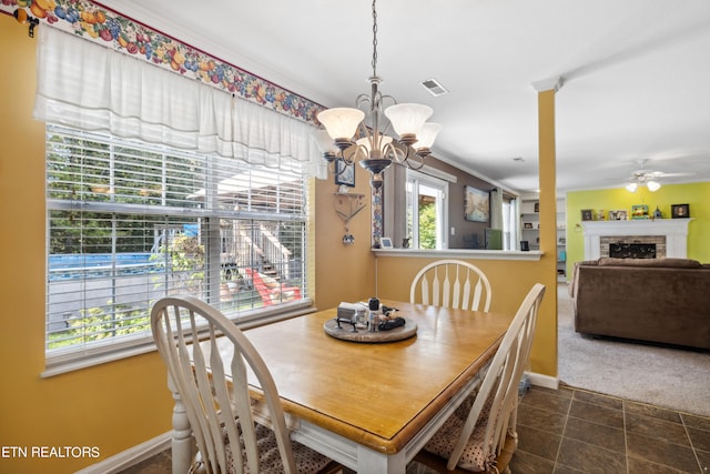 tiled dining space featuring ceiling fan with notable chandelier and crown molding