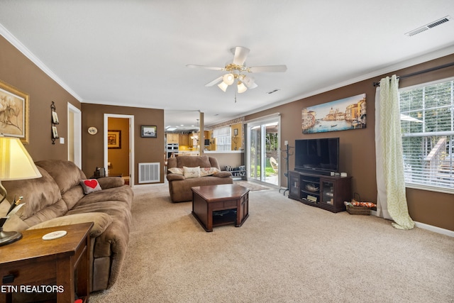 carpeted living room featuring ceiling fan and crown molding