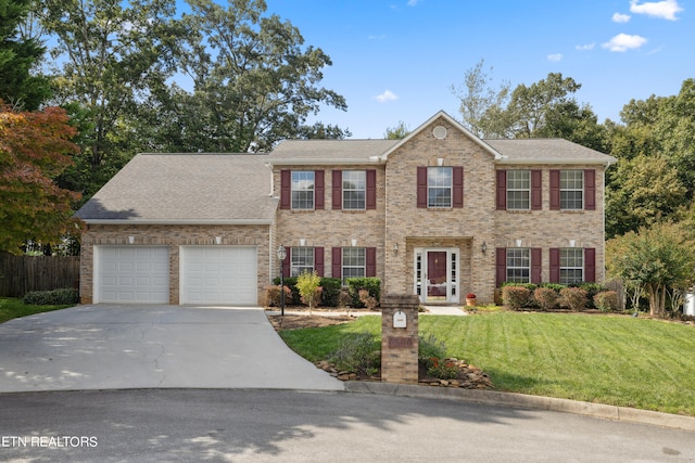 colonial home with a garage and a front yard