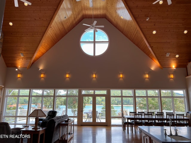 interior space with wood ceiling, a water view, and high vaulted ceiling