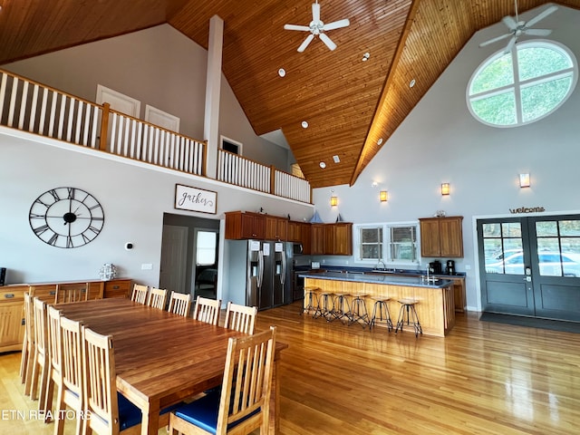 dining area featuring high vaulted ceiling, light hardwood / wood-style flooring, and plenty of natural light