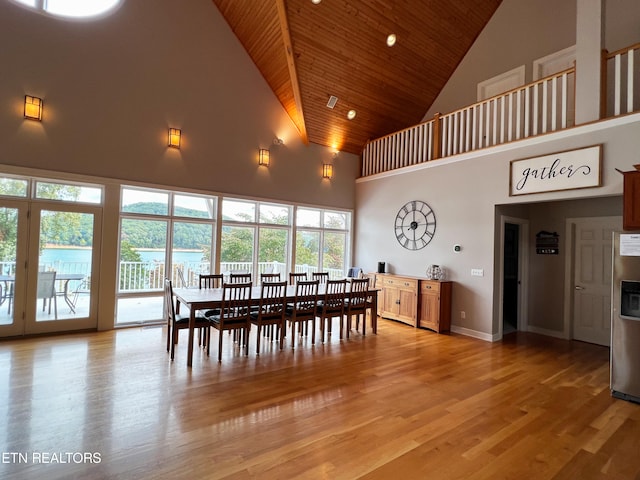 dining space featuring wood ceiling, high vaulted ceiling, and light wood-type flooring