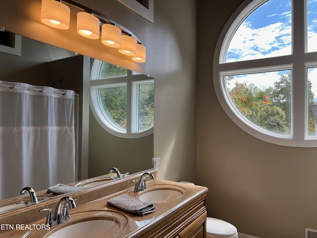 bathroom with vanity, curtained shower, and toilet