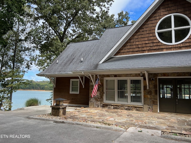 view of front of house with a water view, french doors, and a porch