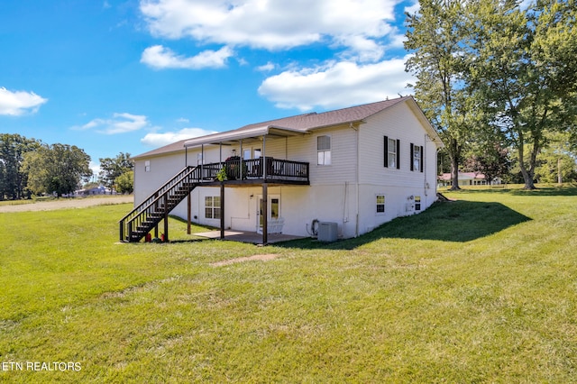 rear view of house featuring cooling unit, a yard, and a wooden deck