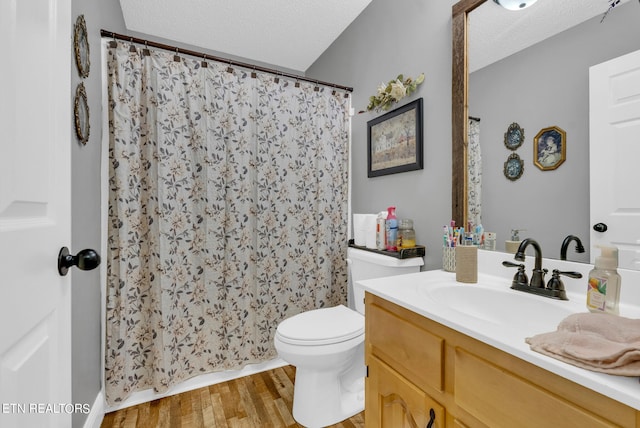 bathroom with hardwood / wood-style floors, vanity, toilet, and a textured ceiling