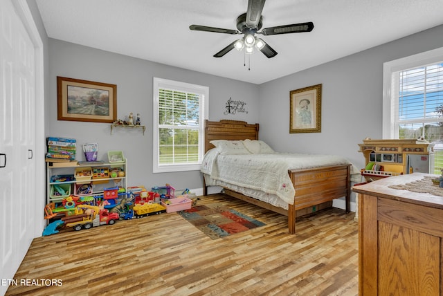 bedroom with ceiling fan and light hardwood / wood-style floors