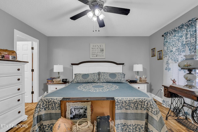 bedroom featuring ceiling fan, a textured ceiling, and light hardwood / wood-style flooring