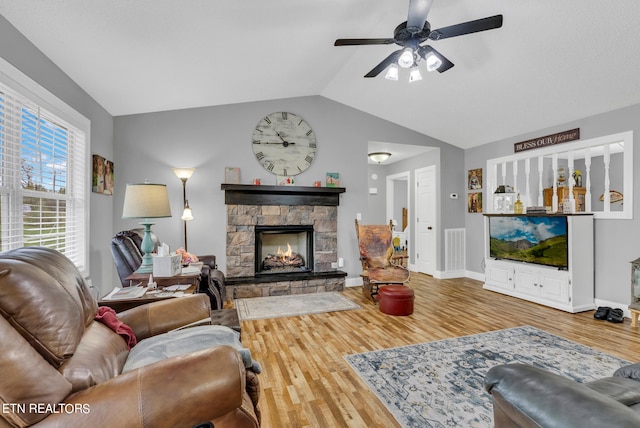 living room with hardwood / wood-style floors, ceiling fan, lofted ceiling, and a fireplace