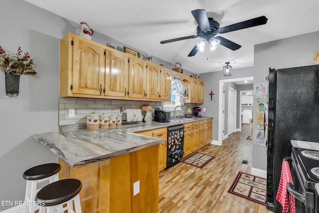 kitchen featuring ceiling fan, electric range oven, backsplash, kitchen peninsula, and a kitchen bar