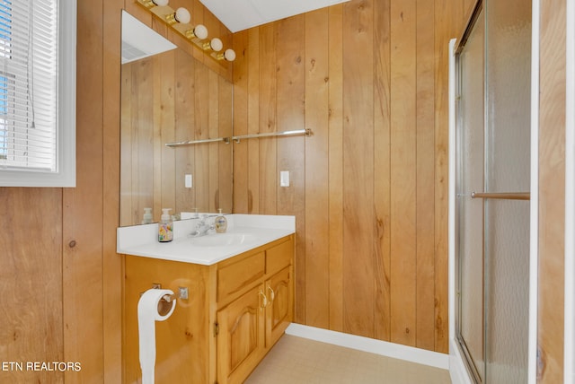 bathroom with vanity, an enclosed shower, and wooden walls