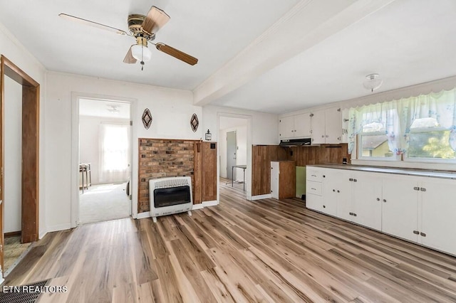 kitchen with heating unit, white cabinetry, ceiling fan, and a healthy amount of sunlight