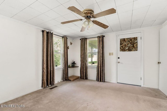 carpeted spare room with ceiling fan