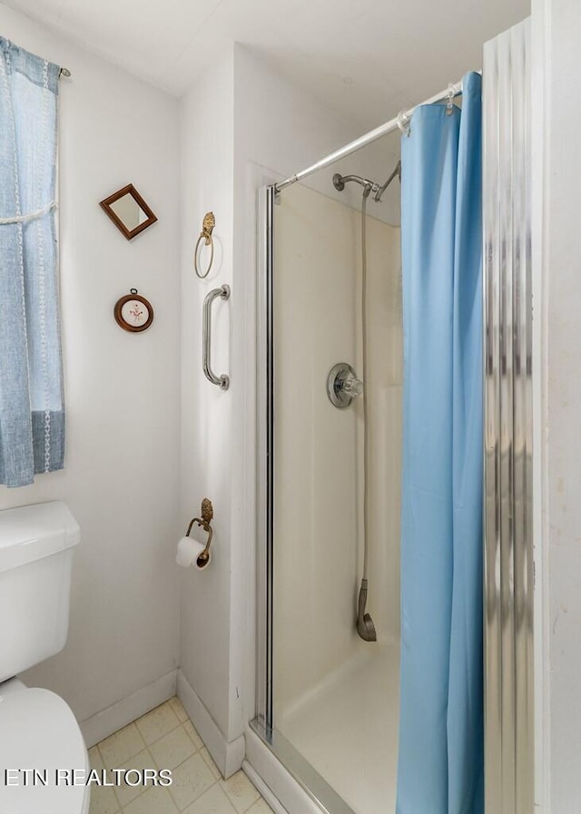 bathroom featuring a shower with curtain, tile patterned flooring, and toilet