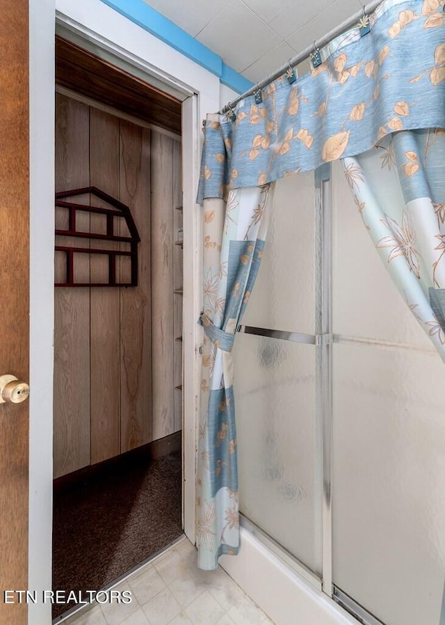 bathroom with walk in shower and wooden walls