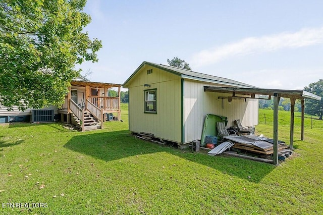 view of outdoor structure featuring a yard and central AC