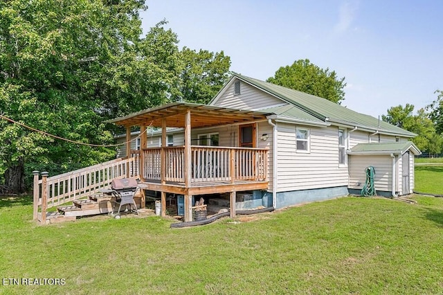 rear view of property with a yard and a wooden deck