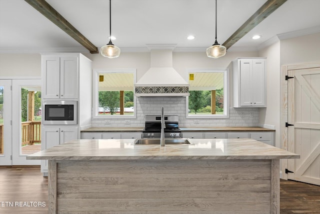 kitchen with white cabinets, custom range hood, stainless steel appliances, and hanging light fixtures