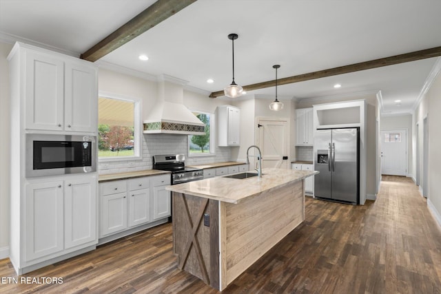 kitchen with appliances with stainless steel finishes, white cabinets, sink, and an island with sink