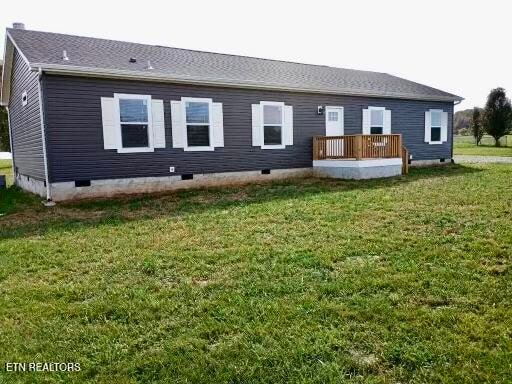 back of house with a deck and a yard