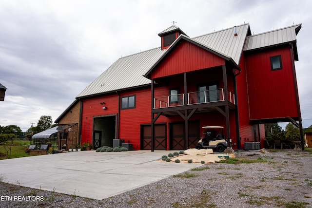 back of property featuring cooling unit, a garage, and a balcony