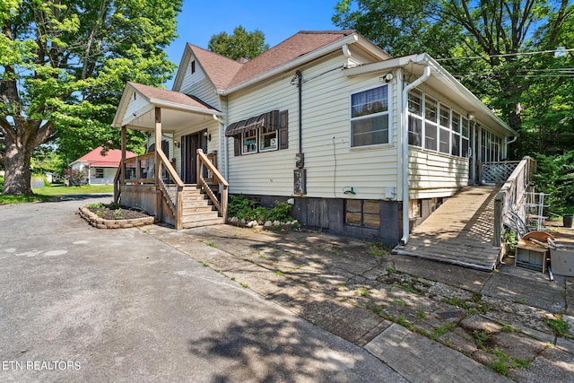 bungalow-style house with covered porch and stairs