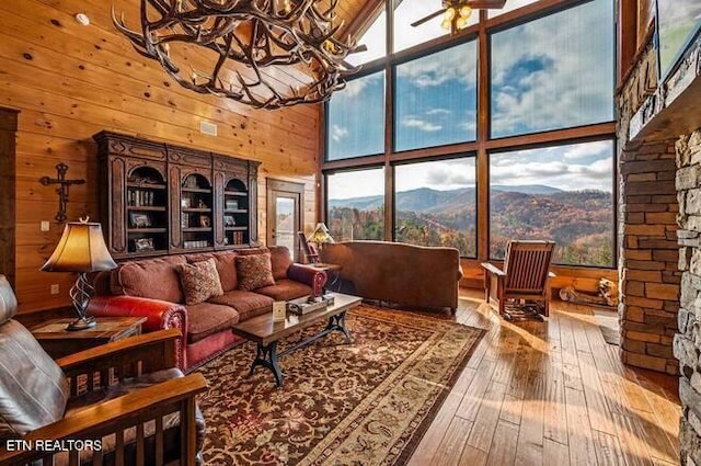 sunroom featuring a mountain view, ceiling fan with notable chandelier, and vaulted ceiling