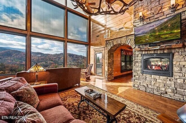 living room featuring hardwood / wood-style flooring, a fireplace, and a high ceiling