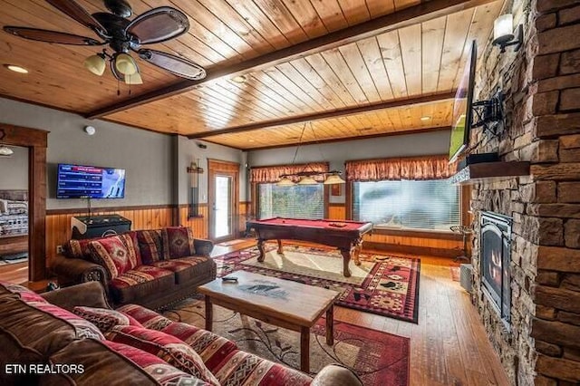 living room with wood walls, a fireplace, wood ceiling, and pool table