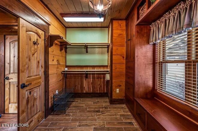 mudroom featuring wooden ceiling and wood walls