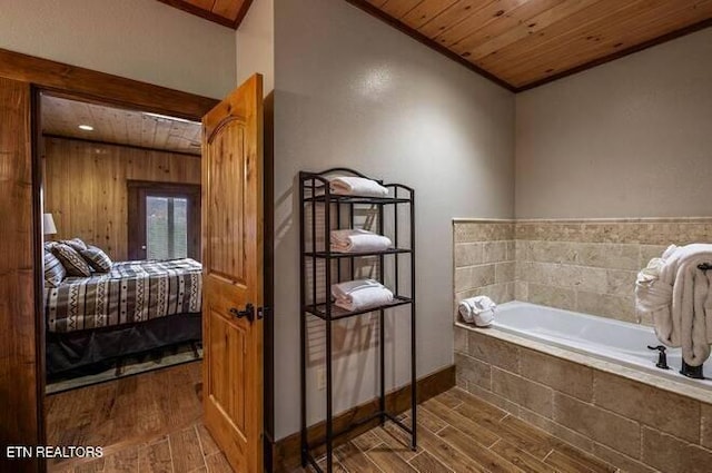 bathroom featuring wood ceiling, crown molding, and tiled bath