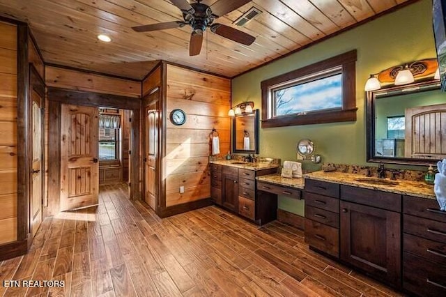 bathroom with wood-type flooring, vanity, wooden ceiling, and wood walls