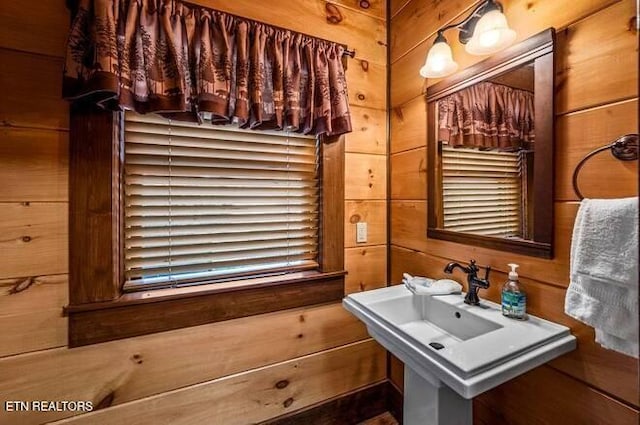 bathroom with wood walls and sink