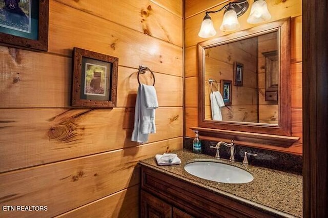 bathroom featuring vanity and wood walls