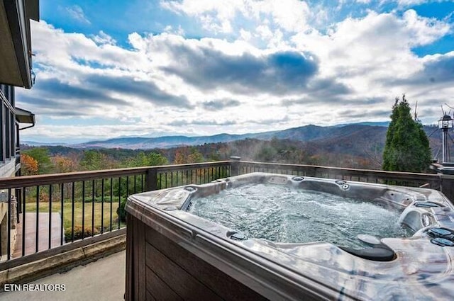 balcony with a mountain view and a hot tub