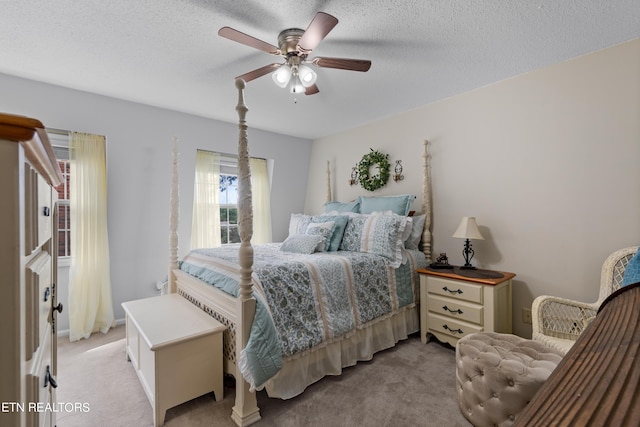 carpeted bedroom with ceiling fan and a textured ceiling